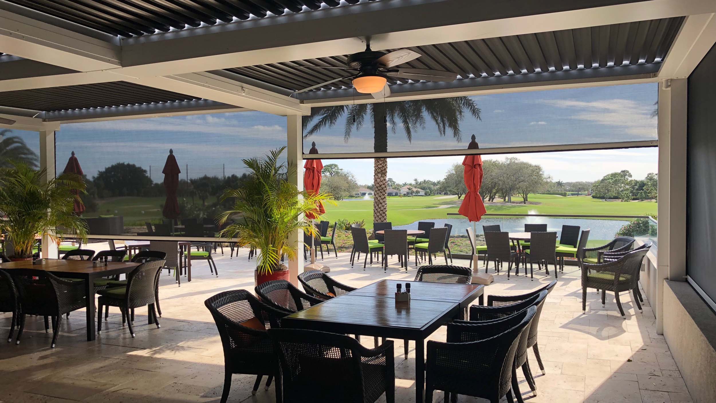 Outdoor patio with green, pink, and purple velvet chairs and a green canopy